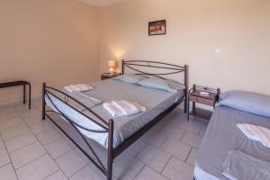 a bedroom with two beds and a lamp on a table at Eleni Studios in Tsilivi