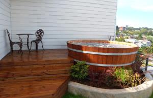 a hot tub on a deck with a table and chairs at Dein Haus Hotel y Departamentos in Puerto Varas