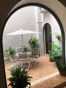 łuk ze stołem, krzesłami i parasolem w obiekcie The Suites & Vintage Apartment at Casa Of Essence in heart of Old San Juan w mieście San Juan