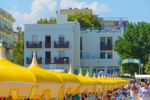 a group of yellow umbrellas in front of a building at Hotel Nuova Medusa Rimini in Rimini