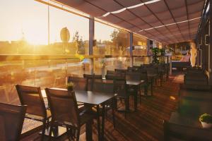 eine Reihe von Tischen und Stühlen auf einer Terrasse in der Unterkunft Mercure Lisboa Almada in Almada