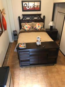 a bedroom with a large bed with a wooden dresser at ★ Gorgeous Patio Room at Casa of Essence located in ♥ of Old San Juan ★ in San Juan