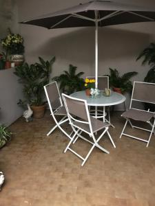 une table et des chaises blanches avec un parasol dans l'établissement ★ Gorgeous Patio Room at Casa of Essence located in ♥ of Old San Juan ★, à San Juan
