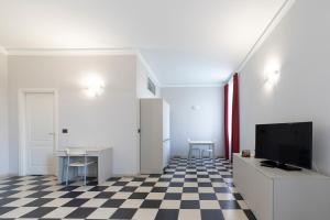 a living room with a tv and a checkered floor at Cascina Marchesa in Turin