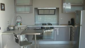 a kitchen with stainless steel appliances and a sink at Appartement Cassis vue mer d'exception in Cassis