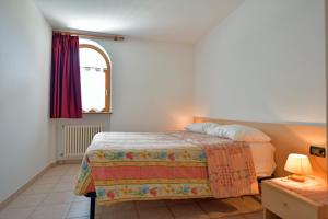 a bedroom with a bed and a window at Agriturismo Fantelli Nicola in Dimaro