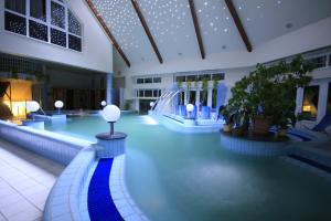 una piscina con scivolo in un edificio di Orchidea Hotel Lipót a Lipót