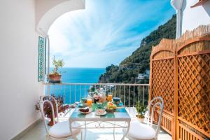 een balkon met een tafel en uitzicht op de oceaan bij Blue Line House Positano in Positano