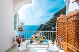 a balcony with a table and a view of the ocean at Blue Line House Positano in Positano