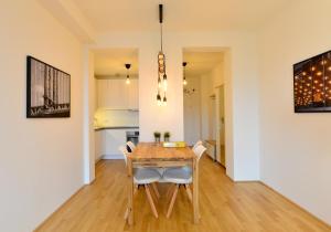 a kitchen and dining room with a wooden table and chairs at Self-Check-In With View & Free Parking in Vienna