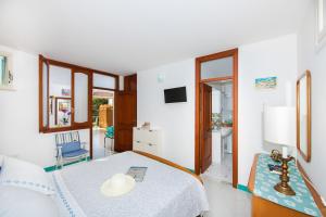 een witte slaapkamer met een bed en een tafel bij Blue Line House Positano in Positano
