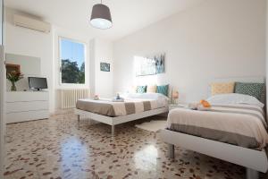 una camera bianca con 2 letti e una TV di La casa di Otto a Firenze