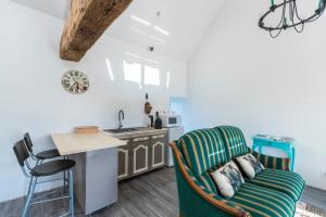 a kitchen with a green chair and a table at Les Colombes de la Baie du Mont Saint-Michel in Aucey-la-Plaine +20 photos