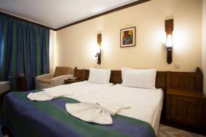 a hotel room with a bed with towels on it at Hotel Tanne in Bansko
