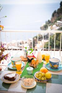 a table with breakfast foods and drinks on a balcony at Blue Line House Positano in Positano