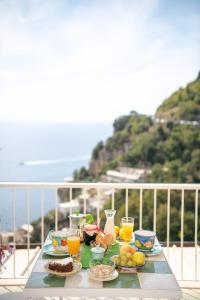 een tafel met eten en drinken op een balkon bij Blue Line House Positano in Positano