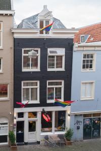 een zwart gebouw met kleurrijke vliegers erop bij Amistad hotel in Amsterdam
