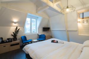 a hotel room with a bed and two blue chairs at Amistad hotel in Amsterdam