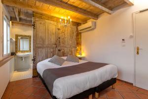 Un dormitorio con una cama grande y un baño. en The Originals Boutique, Clair Hôtel, Martigues, en Martigues