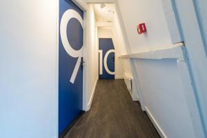 un couloir dans un bureau avec une porte bleue et blanche dans l'établissement Amistad hotel, à Amsterdam