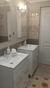 a white bathroom with two sinks and a mirror at Ásványráró Apartman House in Ásványráró