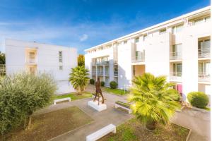 a statue in a courtyard in front of a building at City Résidence Avignon in Avignon