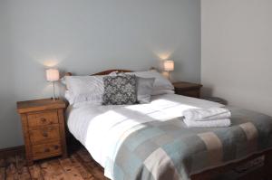 a bedroom with a bed with two night stands and two lamps at Penny Post Cottage in Warton +7 photos