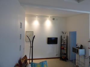 a living room with a couch and a tv on a wall at Gîte de Preuilly in Auxerre