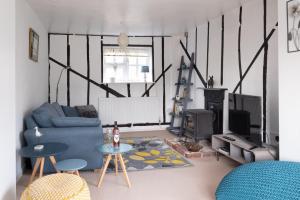 a living room with a blue couch and a fireplace at Bay Cottage in Thorpeness