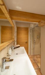 ein Badezimmer mit einem weißen Waschbecken und einer Dusche in der Unterkunft Haus Horngacher in Fieberbrunn