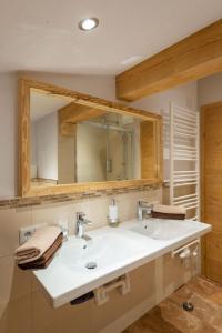 ein Badezimmer mit einem weißen Waschbecken und einem Spiegel in der Unterkunft Haus Horngacher in Fieberbrunn