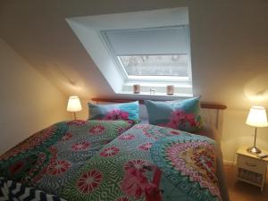 a bedroom with a bed with a flowery comforter and a window at Alte Pastorei in Hinte