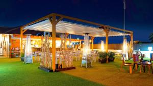 a pavilion with tables and chairs under it at night at FBC Fortuny Resort - Adults Only in Maspalomas