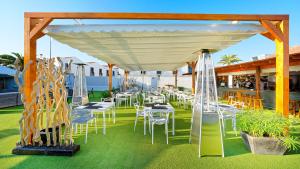 a group of tables and chairs under a pavilion at FBC Fortuny Resort - Adults Only in Maspalomas