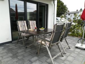 un patio con mesa y 4 sillas en Haus Baltic Cube, en Börgerende-Rethwisch