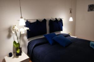 ein Schlafzimmer mit einem blauen Bett mit zwei blauen Kissen in der Unterkunft I Colori di Mag in La Spezia