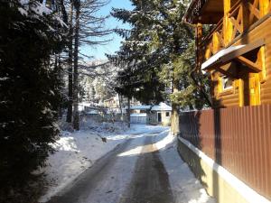 a snow covered road in front of a house at Krym in Yaremche