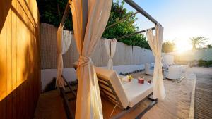 a patio with curtains and a table and chairs at FBC Fortuny Resort - Adults Only in Maspalomas