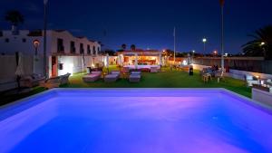 a backyard with a swimming pool at night at FBC Fortuny Resort - Adults Only in Maspalomas