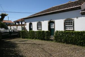 a white house with a cobblestone driveway at Quinta dos Figos "5 Trevos GOLD" in Praia da Vitória