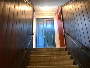 una puerta azul en un pasillo con escaleras en Melusina Ca' Bernarda Venice Historical Center, en Venecia