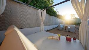 a patio with a white table and chairs and curtains at FBC Fortuny Resort - Adults Only in Maspalomas