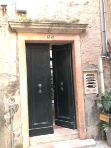 two black doors in a stone building with the number at Ca' Bernarda in Venice