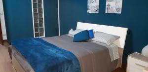 a blue bedroom with a bed with a laptop on it at Domus Mea in Trabia