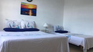 een slaapkamer met 2 bedden en een schilderij aan de muur bij My Dream Apartments in Lagun