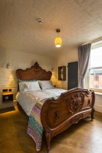 Un dormitorio con una gran cama de madera y una ventana en McGettigan's Townhouse - Olives & Figs Bistro, en Dublín