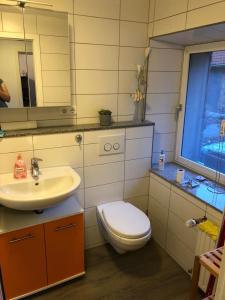 a bathroom with a toilet and a sink at Ferienwohnung Übach Palenberg Marktplatz in Übach-Palenberg