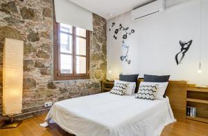 バルセロナにあるLoft en Gràcia ArchsenseApartmentsのレンガの壁、ベッド付きのベッドルーム1室