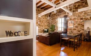 a living room and dining room with a stone wall at Loft en Gràcia ArchsenseApartments in Barcelona