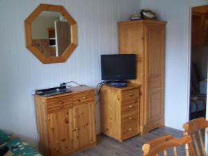 Cette chambre dispose d'une télévision sur une commode en bois et d'une télévision sur une chaise en bois. dans l'établissement Spacieux studio Pré de chartreuse 2, à Saint-Pierre-de-Chartreuse